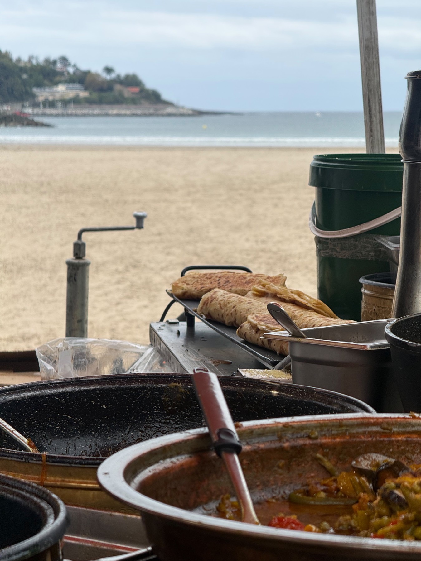 Panes marroquíes enrollados tostándose en la plancha, con la playa de Hendaya al fondo