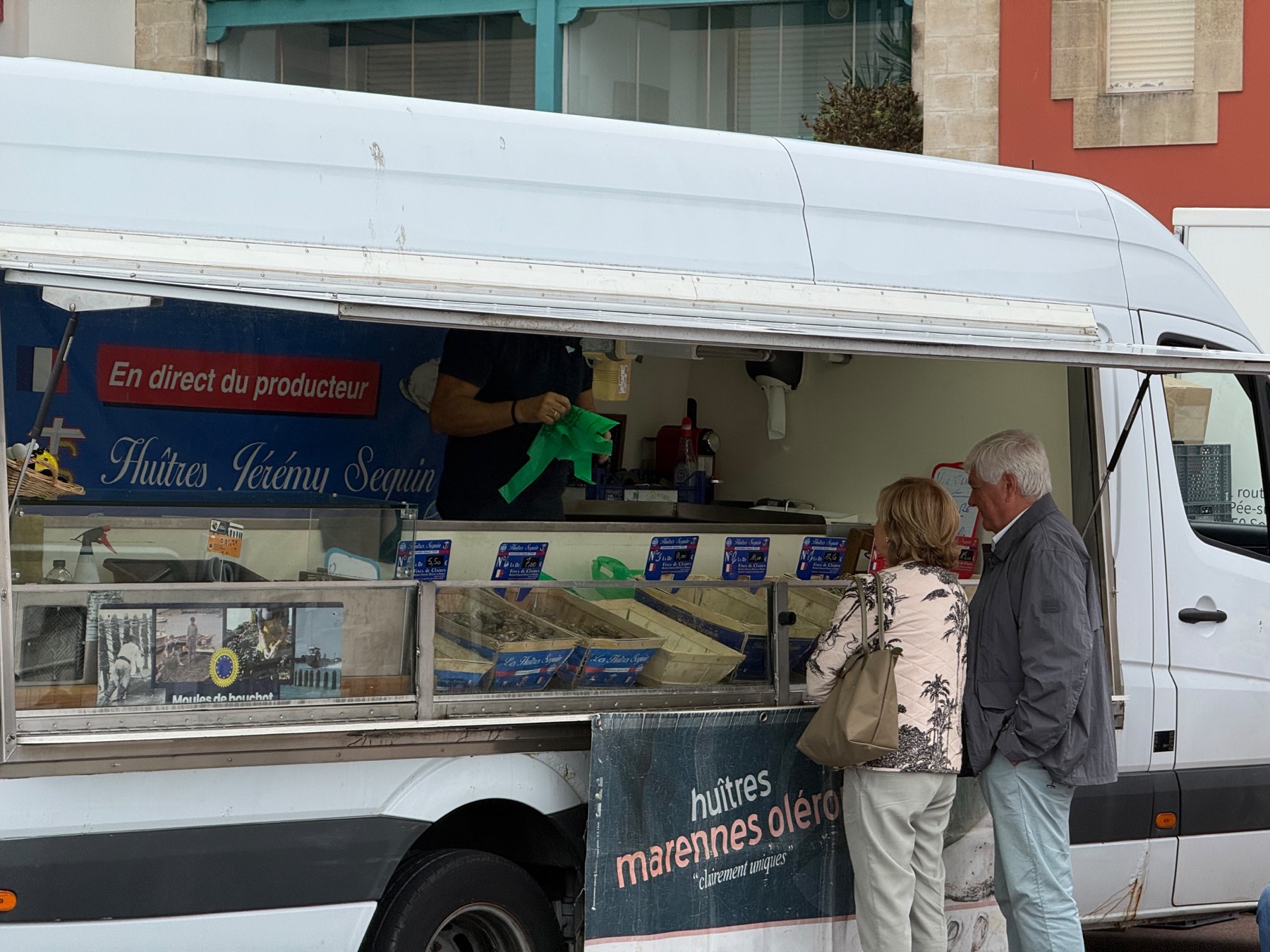 Puesto de ostras Marennes-Oléron en el mercado de Hendaya, con clientes comprando